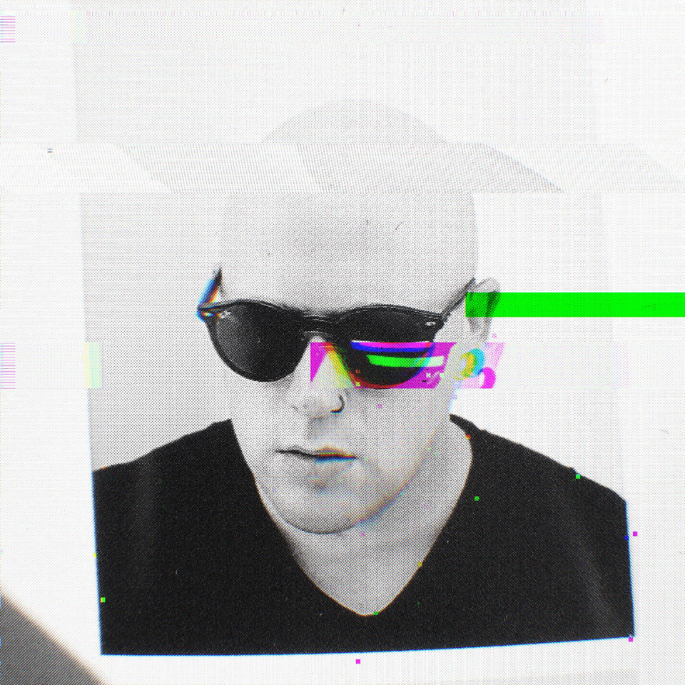 Picture of a bald headed man with black sunglasses with a green stylised glitch effect.